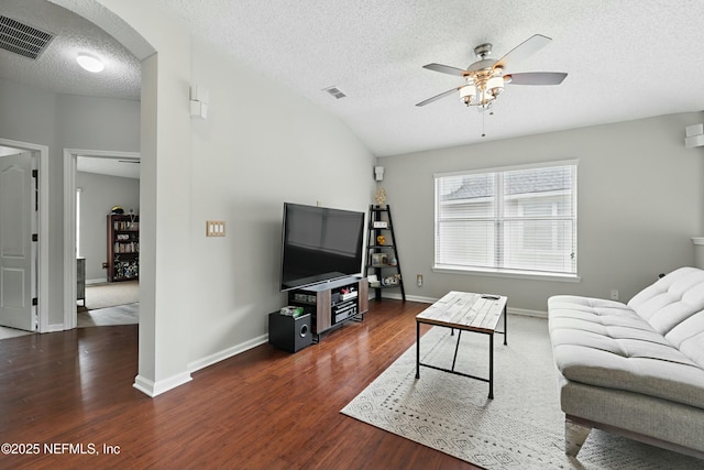 living room with arched walkways, ceiling fan, wood finished floors, and visible vents