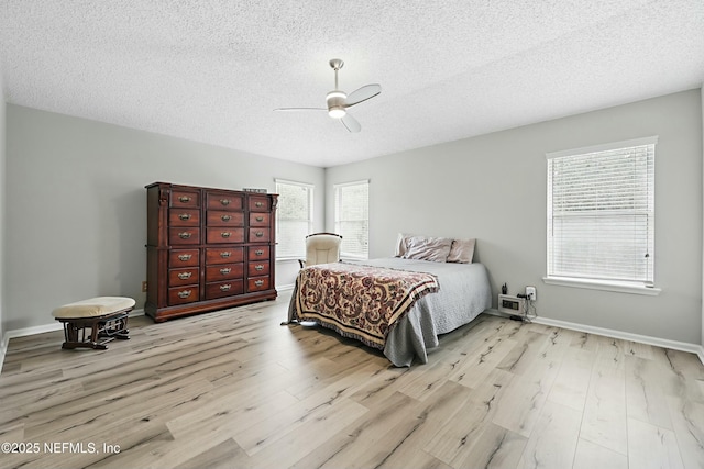 bedroom featuring a textured ceiling, wood finished floors, and a ceiling fan