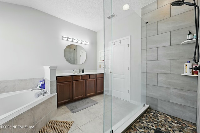 full bathroom with a garden tub, visible vents, vanity, a textured ceiling, and tiled shower