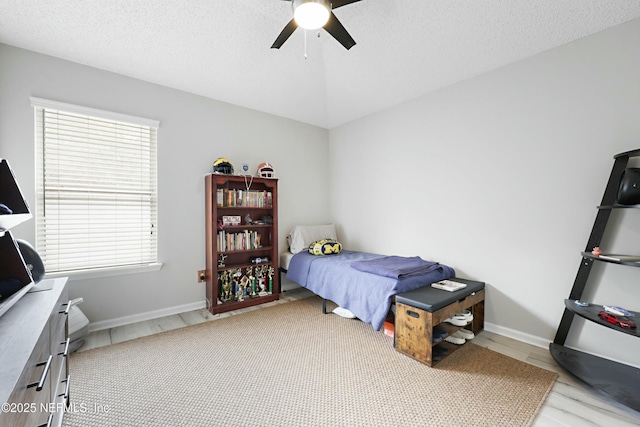 bedroom with baseboards, a ceiling fan, and a textured ceiling