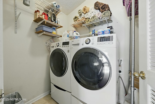 laundry room featuring a textured ceiling, laundry area, independent washer and dryer, and baseboards