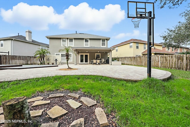 back of house with a yard, a fenced backyard, stucco siding, and a patio