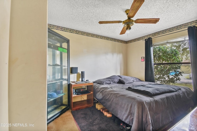 bedroom featuring carpet, a ceiling fan, and a textured ceiling