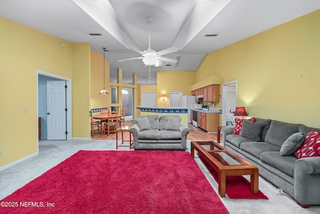 living area featuring high vaulted ceiling, visible vents, and baseboards