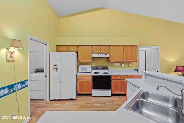 kitchen with light countertops, a sink, washer / dryer, white appliances, and under cabinet range hood