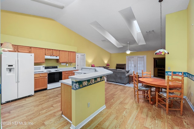 kitchen featuring white appliances, open floor plan, light countertops, under cabinet range hood, and pendant lighting