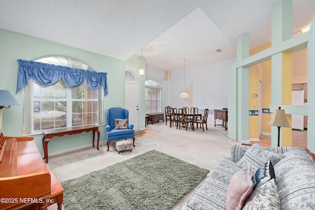 living room with a textured ceiling, carpet, and baseboards