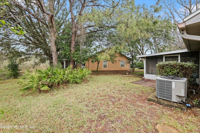 view of yard with a sunroom and central AC