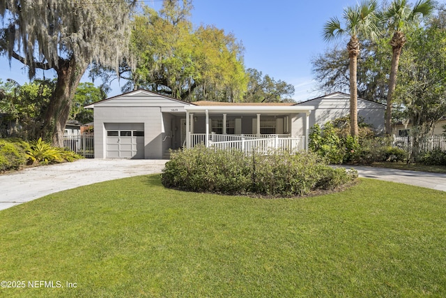 ranch-style house with driveway, covered porch, an attached garage, and a front yard