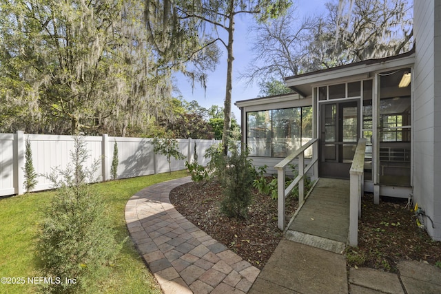 view of yard featuring fence and a sunroom