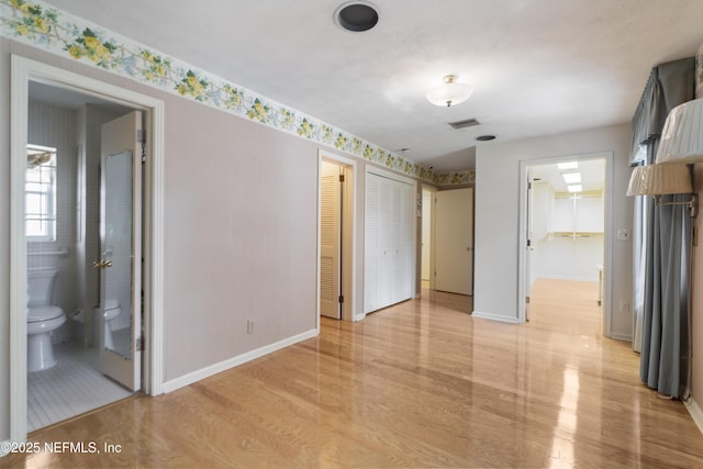 interior space featuring light wood-style flooring and baseboards