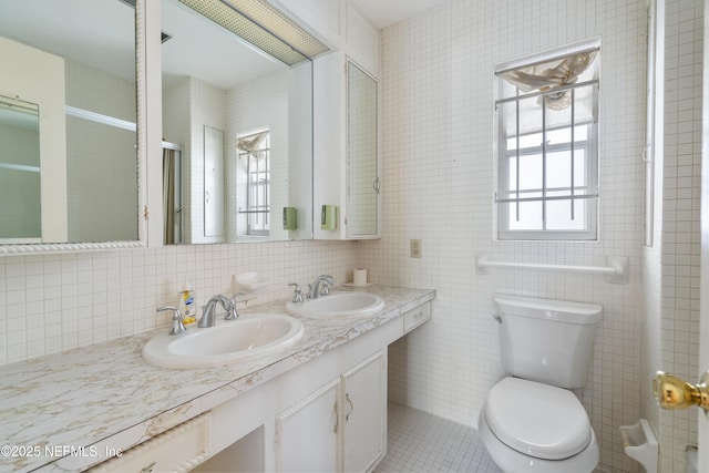 full bath featuring a sink, tile walls, and toilet