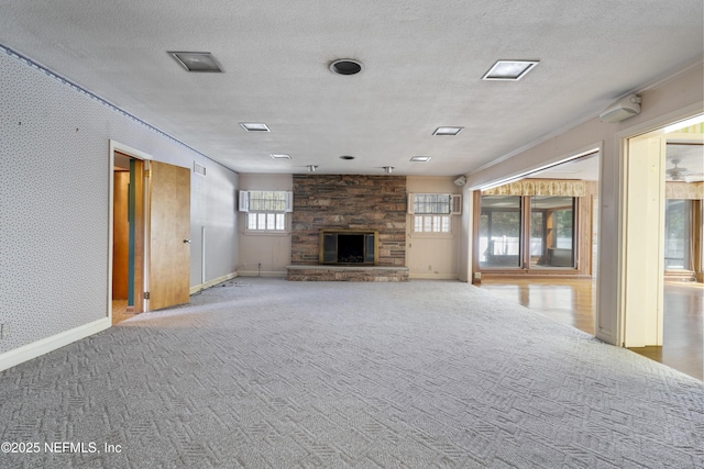 unfurnished living room with carpet flooring, a fireplace, a textured ceiling, and wallpapered walls