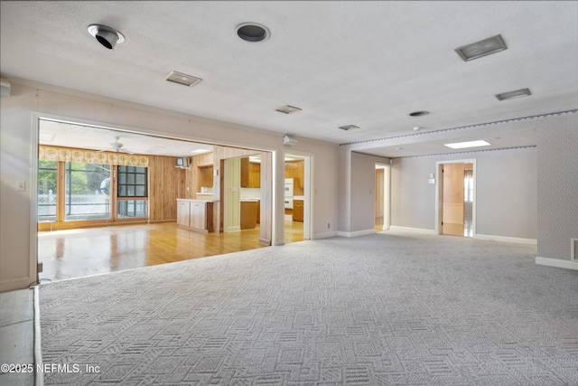 unfurnished room with light carpet, visible vents, and baseboards