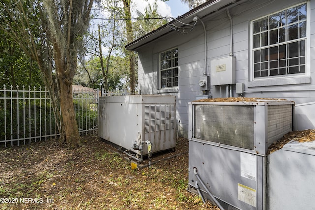 exterior space with electric meter and fence