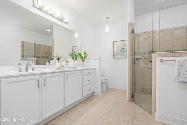 bathroom featuring toilet, vanity, baseboards, a shower stall, and tile patterned floors