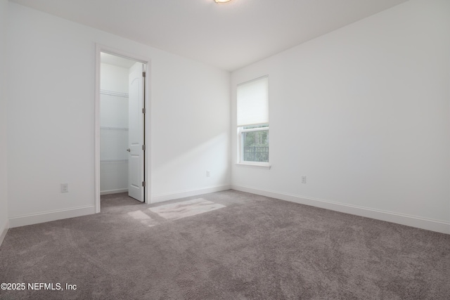 empty room with baseboards and carpet flooring