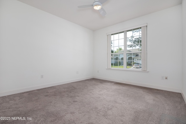 carpeted empty room with ceiling fan and baseboards