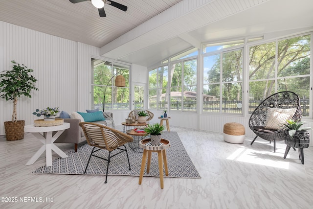 sunroom with a ceiling fan and vaulted ceiling with beams