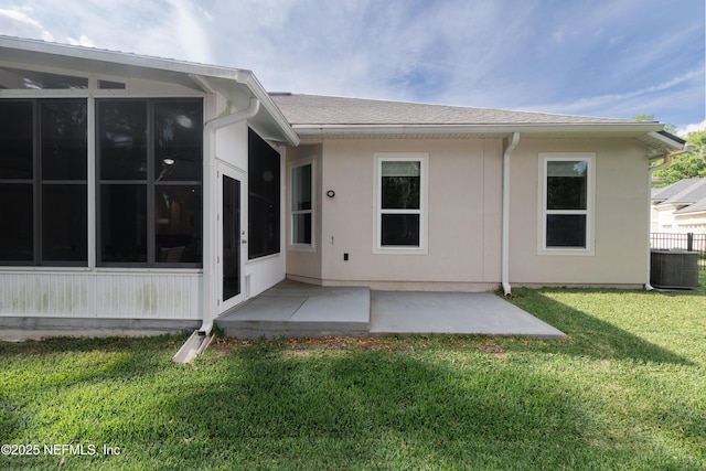 rear view of property with central AC, a yard, a shingled roof, and a patio