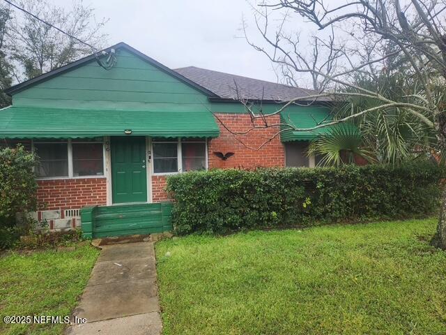 view of front of house with a front yard and brick siding