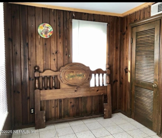 foyer entrance featuring ornamental molding, wood walls, and light tile patterned floors