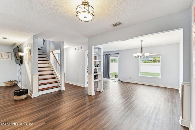 foyer entrance featuring baseboards, visible vents, dark wood-style floors, stairway, and a textured ceiling