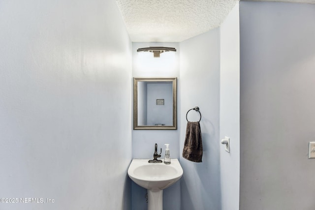 bathroom with a textured ceiling and a sink