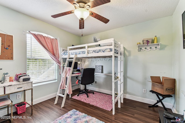 bedroom with ceiling fan, baseboards, dark wood finished floors, and a textured ceiling