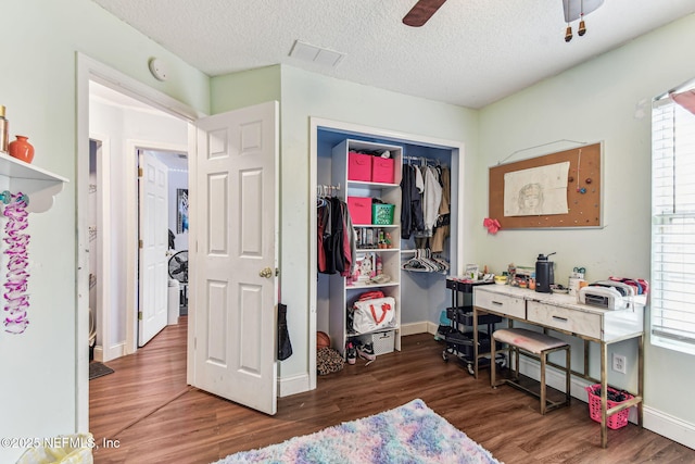 bedroom featuring a textured ceiling, visible vents, baseboards, a closet, and dark wood-style floors