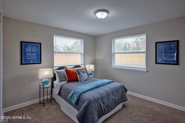 bedroom with carpet, a textured ceiling, and baseboards