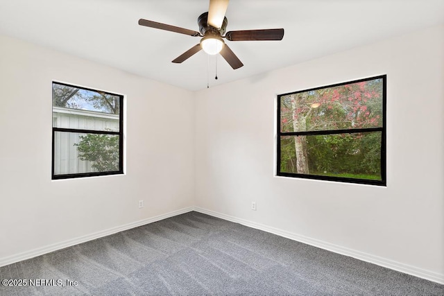 carpeted spare room with ceiling fan and baseboards