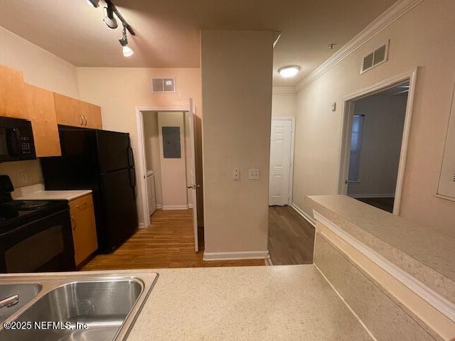 kitchen featuring light countertops, a sink, visible vents, and black appliances