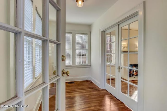 doorway to outside with french doors, wood finished floors, visible vents, and baseboards