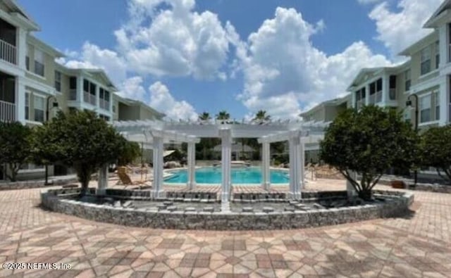 view of property's community featuring a pool and a pergola