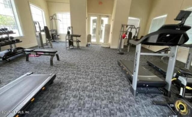 exercise room featuring dark colored carpet, french doors, and baseboards