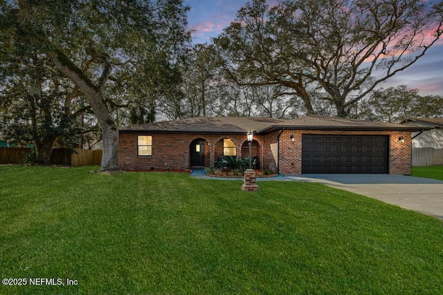 ranch-style home with concrete driveway, brick siding, a lawn, and fence