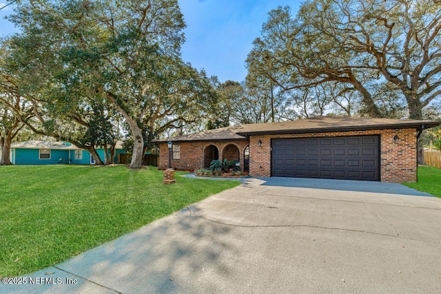 ranch-style home with driveway, a front lawn, and brick siding