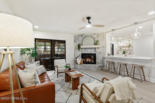 living room with ceiling fan, recessed lighting, a fireplace, and baseboards