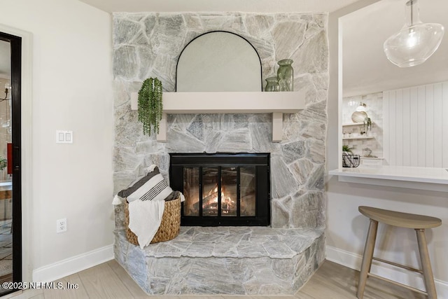 room details with a fireplace, baseboards, and wood finished floors