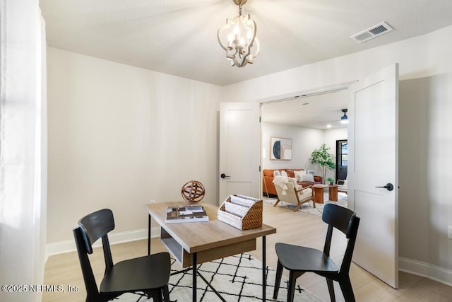 dining space featuring visible vents, a notable chandelier, and baseboards