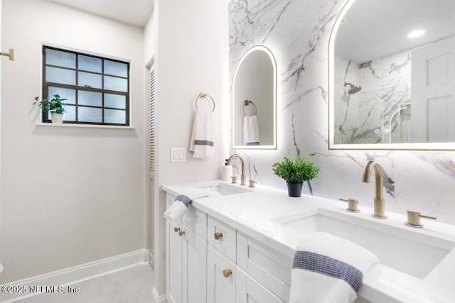 full bath with a sink, double vanity, a marble finish shower, and recessed lighting