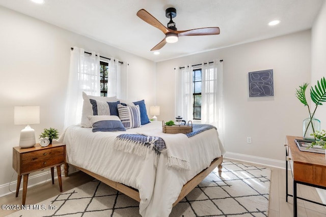 bedroom featuring light wood-style floors, recessed lighting, multiple windows, and baseboards