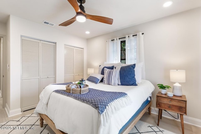 bedroom featuring ceiling fan, recessed lighting, visible vents, baseboards, and two closets