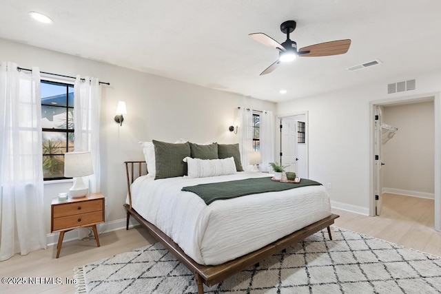 bedroom featuring light wood-style floors, visible vents, and baseboards