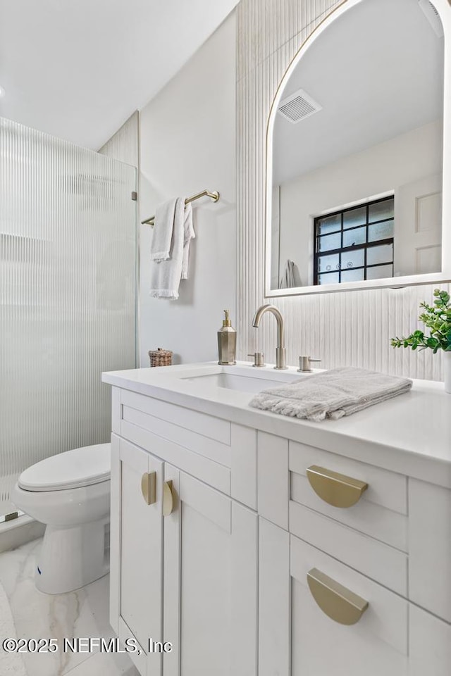 bathroom with marble finish floor, visible vents, toilet, a stall shower, and vanity