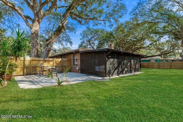 exterior space featuring a patio area, a lawn, a fenced backyard, and brick siding