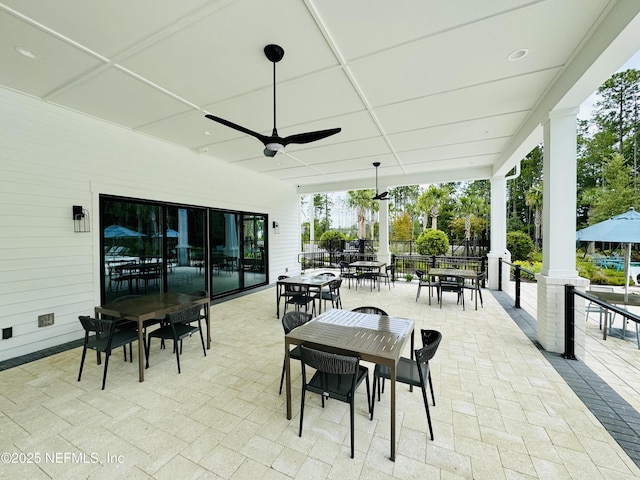 view of patio with outdoor dining space, fence, and a ceiling fan