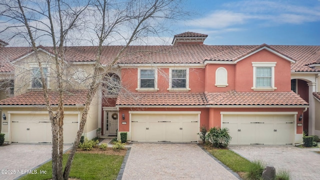 view of front of property featuring a tiled roof, driveway, and stucco siding