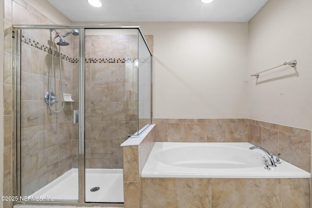 bathroom with a shower stall, a bath, and recessed lighting